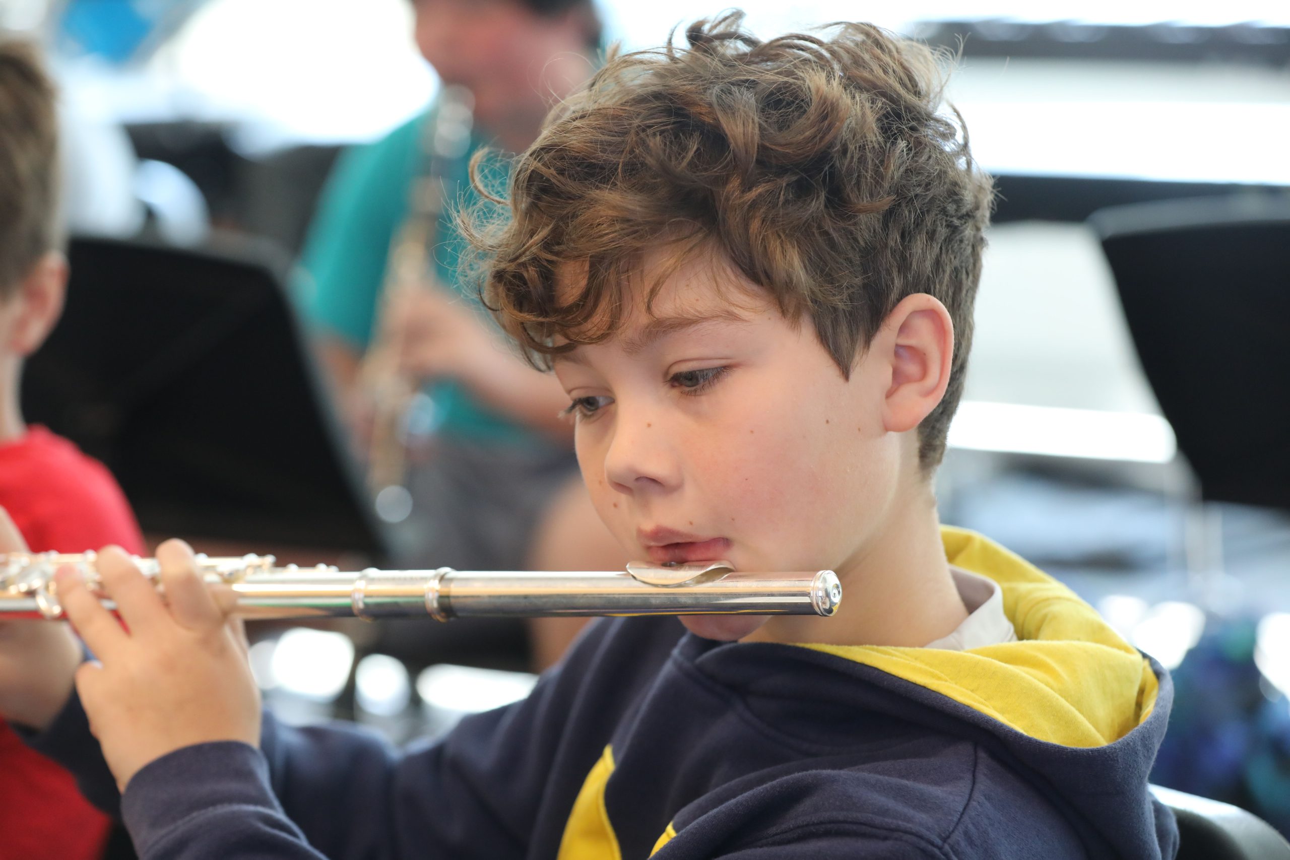 Young male students close up of him playing the flute.