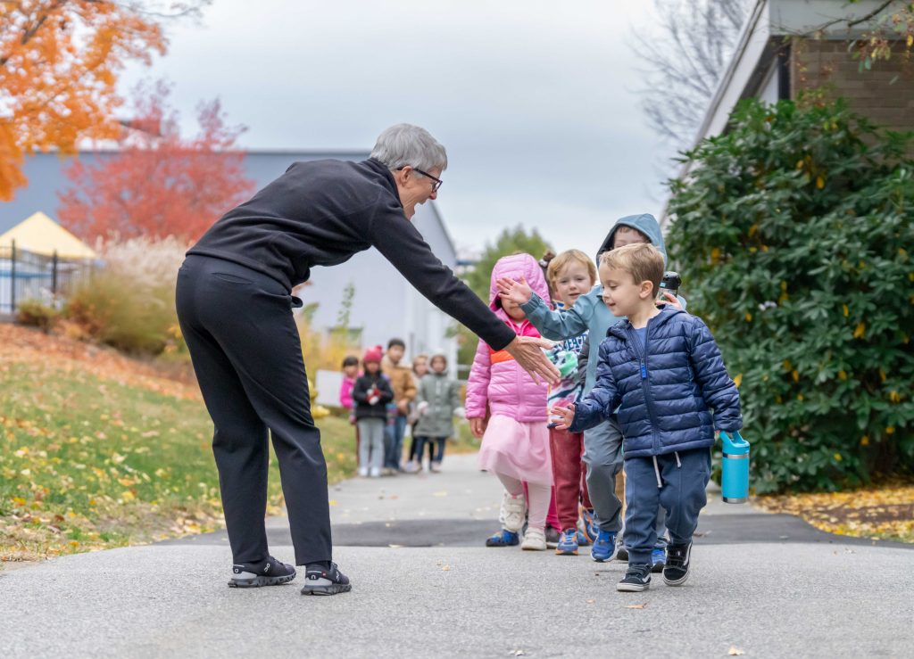 Bancroft School Lower School students greet Head of School Stephanie Luebbers on the pathway in Worcester, MA.