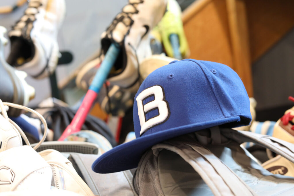 Bancroft School Worcester, MA baseball caps and bats lined up in a hallway.