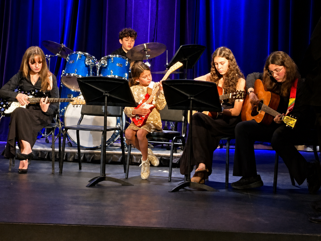 Students in guitar band playing on stage at Bancroft School in Worcester, MA.