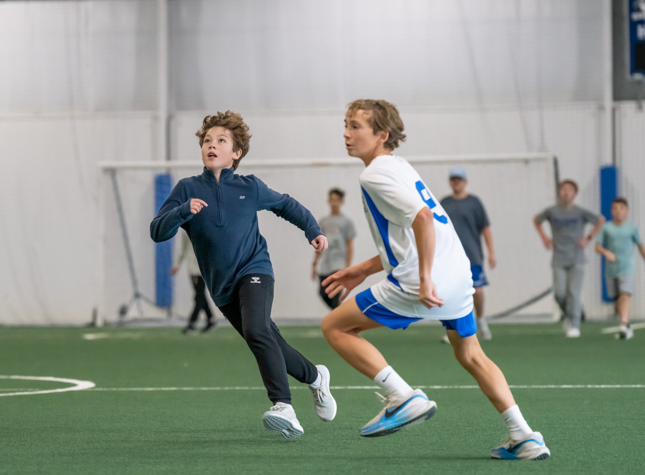 Two students playing pick up soccer in Bancroft School's Field House.