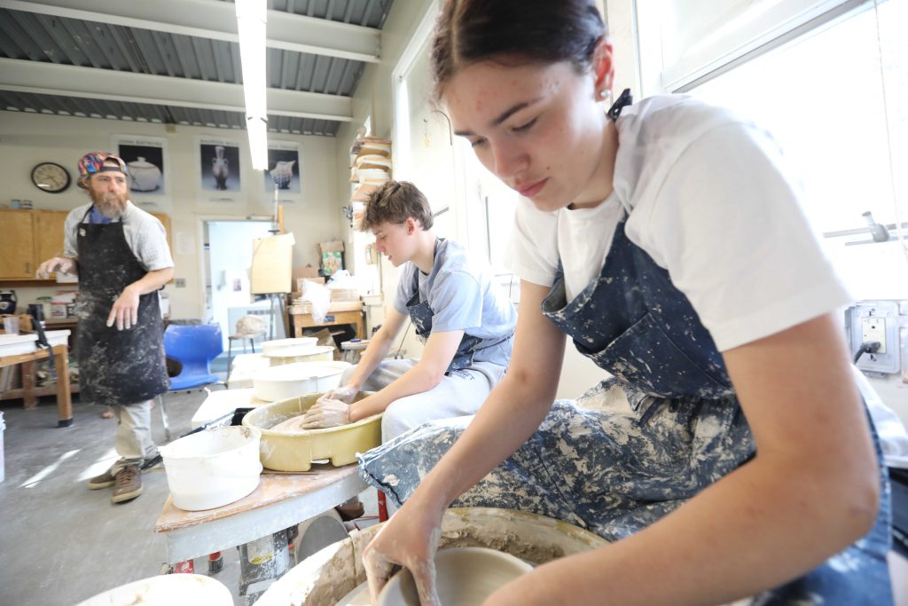 Upper School students in art class at Bancroft School in Worcester using a pottery wheel.